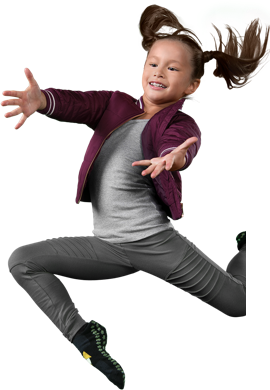 Girl jumping with confetti and green background.