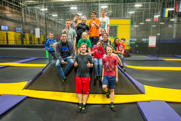 Group of teens posing on a trampoline.