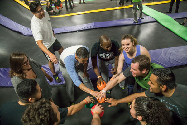 Team huddle, people with hands in the center.