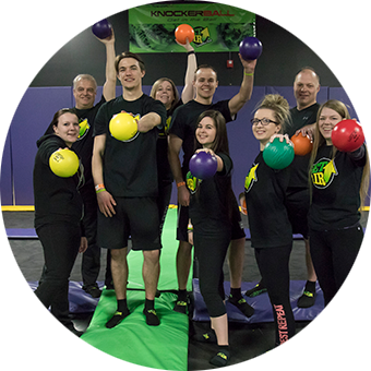 Group of people holding dodgeballs, ready to play.