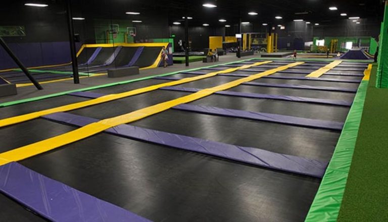 Empty indoor trampoline park with multiple trampolines.