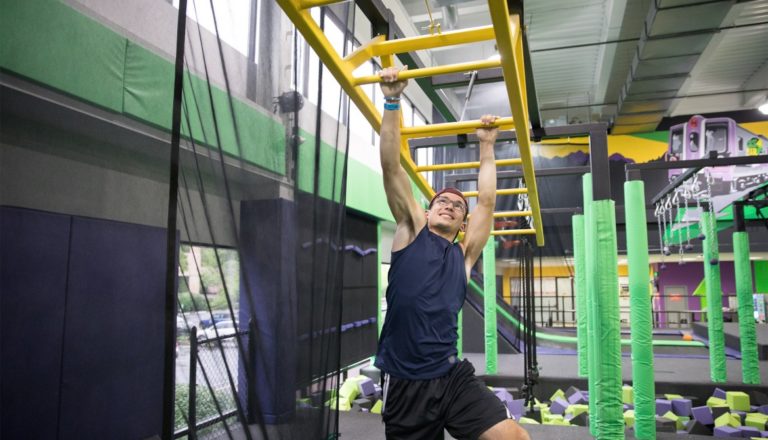 Man swinging on monkey bars at Get Air.