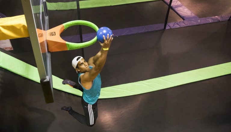 Man dunking basketball through a hoop.