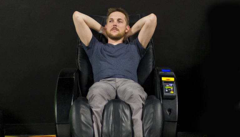 Man reclining on a massage chair, looking relaxed.