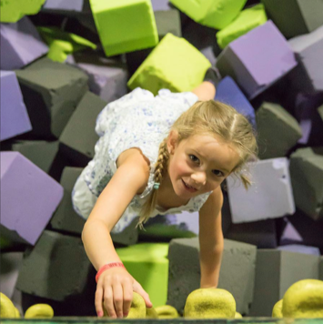 Girl climbing in a foam pit at Get Air, Facebook page