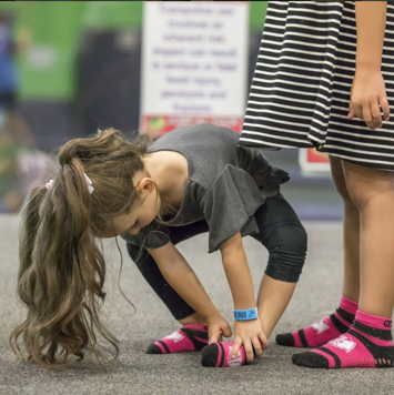 Young girl adjusting her jump socks, Instagram page