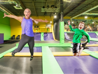 Woman and boy jumping on trampolines at Get Air.