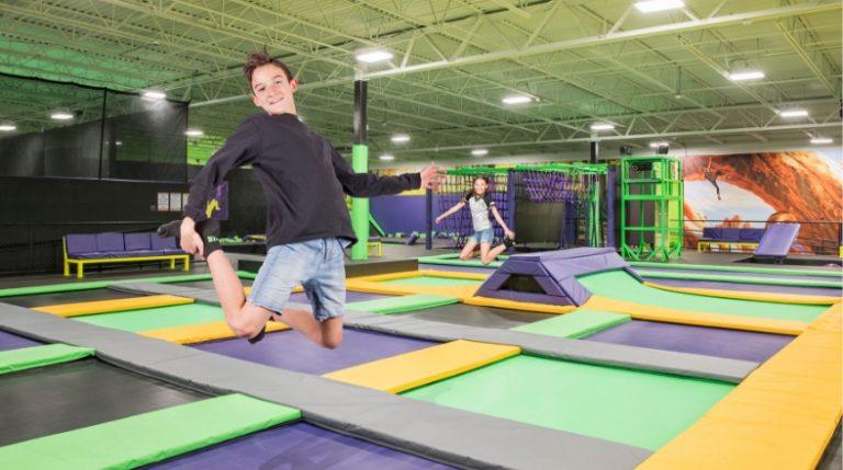 Boy jumping on trampolines at Get Air, with another kid in the background.