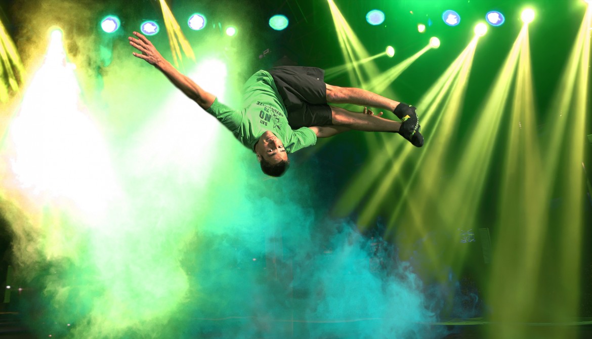 Person performing a backflip with colorful lights.